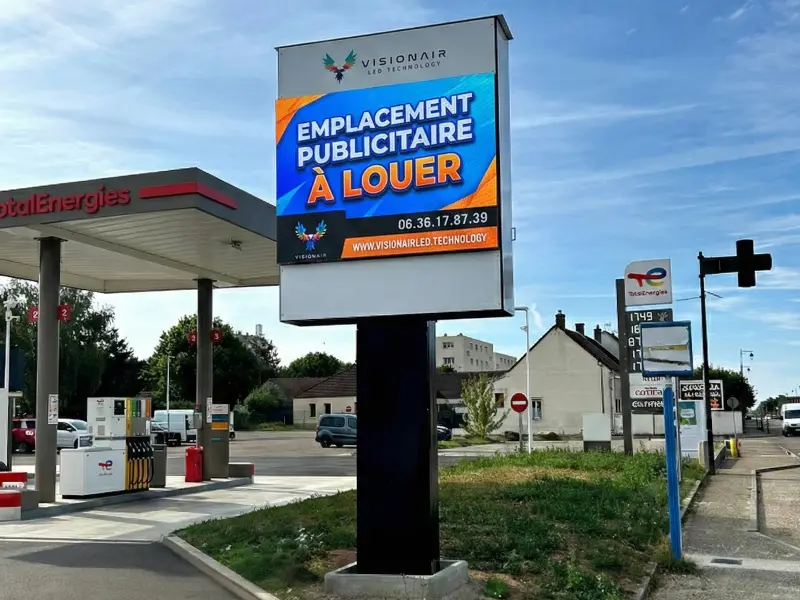Écran géant publicitaire sur parking de zone commerciale grand passage